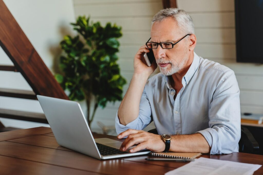 Man on a laptop while making a call